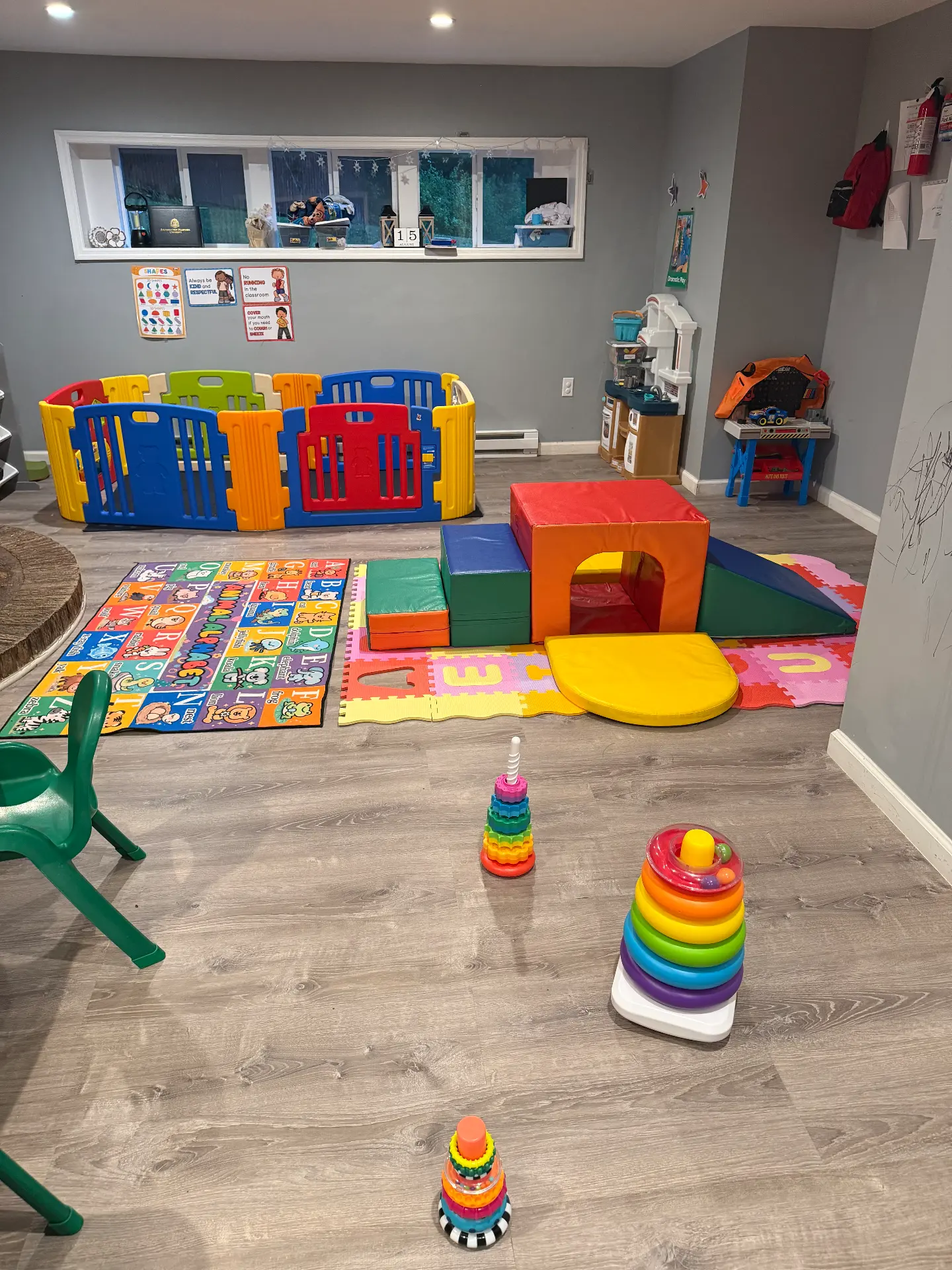 Alphabet rugs and soft foam climbing blocks set out on the playroom floor